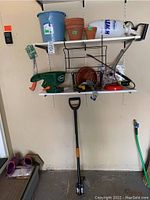 Shelf with planters, bucket, sprayer, Scotts spreader, and metal plant frame