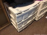 Front side view showing three large white plastic drawers and the top surface of the organizer