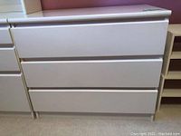 Front view of white 3-drawer dresser showing clean finish and integrated drawer pull grooves.