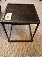 Top view of the square metal side table showing the flat surface and metal frame structure.