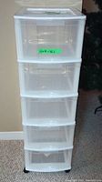 Front view of plastic 5-drawer organizer showing all drawers closed, with label showing dimensions 12x14x38.5 inches.