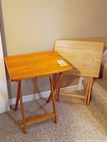 Two wooden folding TV trays, one assembled and standing and one folded, showing size and finish
