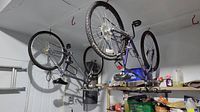 Overview of two hanging bikes showing both frames and wheels