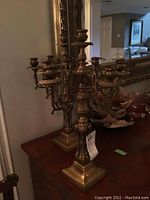 Pair of brass candelabras displayed on wood surface
