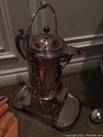 Full view of the silver plated samovar showing the lid, handle, and base tray