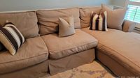 Front view of full sectional showing loose seat and back cushions and decorative pillows