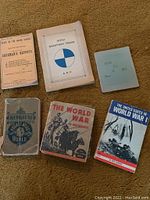 Six antique books laid out in two rows, showing various historical and war-themed titles, with visible wear and aged paper.