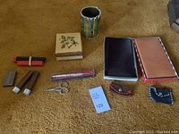 Full lot arrangement on carpet including wooden box, pencil cup, wax seal stamps, coin purses, notepads, wax sticks, scissors, and metal stamp block.
