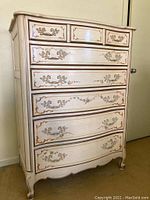 Front view of the French Provincial chest of drawers showing the six drawers, painted floral and gold details, scalloped legs, and curved edges.