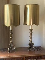 Pair of brass based lamps with gold tone metallic shades, showing full lamps and cords.