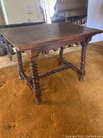 Full view of dark stained solid wood Jacobean style side table showing rectangular top and turned legs.