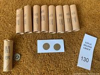 Nine rolls of bus tokens on a brown surface with examples of New York City and Rochester tokens displayed on white cards.