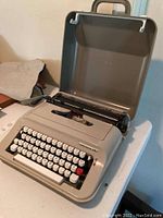 Open Underwood 319 typewriter with keyboard visible in gray case.