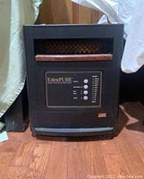 Front view of brown and black EdenPure quartz infrared portable heater showing the control panel and branding.