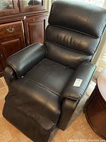 Black leather recliner chair from a top-side angle showing overall condition and wear.