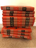 Stack of red hardcover Childcraft fiction books. Spines labeled and numbered, some labeled 'Fiction and Fun'.