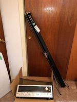 Knox projector screen casing leaning against door alongside Pioneer receiver