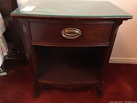 Front view of the Gibbard wood night table showing drawer, metal pull, lower shelf, and leg design.