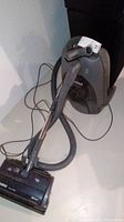 Full view of the Kenmore canister vacuum cleaner showing vacuum unit, hose, and vacuum head lying on floor.