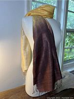 Wrap draped on a mannequin showing the silk's gradient from golden yellow to deep brown and texture.