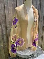 Scarf displayed draped on mannequin showing length and floral pattern.