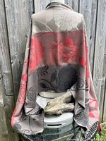 Back view of jacquard floral patterned pashmina wrap displayed over a chair with wood background.