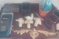 Overall lot view showing calculator, napkin holder, hand tools, pan, and decorative night lights arranged on table.