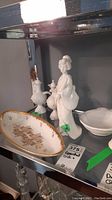 Shelf view showing pair of cruet bottles, oval dish, Geisha figurine