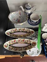 Photo of two decorated ceramic trays, Dresden bowl, and Churchill teapot with cup and saucer