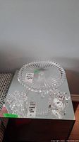 Photo of the Mikasa crystal cake stand showing round top plate with faceted edge, crystal table clock, and decorative crystal box with lid.