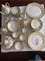 Overall layout of dinner plates, side plates, cups, saucers and teapot, coffee pot and sugar bowl on table