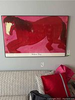 Full frontal view of the framed print hanging on a wall above a sofa.