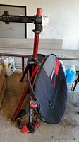 Photo of bicycle stand, wheel sleeve, tire pump, and tire in a garage setting
