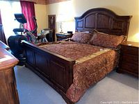 Full view of assembled king bed in room with headboard, footboard, side rails and bedding