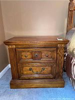 Front view of a wood night stand showing drawer details and fluted columns on sides