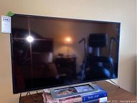 Front view of the TV showing full screen and rectangular silver stand.