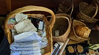 Basket filled with linens, fabric swatches and napkins, also visible smaller baskets stacked