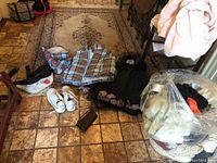 Photo of all items laid out on tiled floor with some folded and some placed loose, showing outerwear, shoes, and bag.