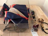 Photo of scarves and costume jewelry including earrings, bangle and a hair straightener