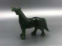 Left-side angle view of the dark green jade horse carving, showing detailed mane and tail.