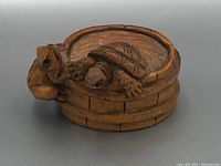 Front and side view showing carved turtle inside barrel and monkey figure on barrel side
