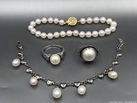 Full view of pearl jewellery set including two rings, pearl bead bracelet with gold-tone clasp, and a silver-tone bracelet with pearl charms and heart-shaped links.