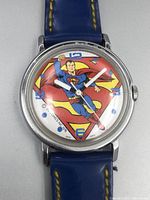 Front close-up of the Superman wristwatch showing detailed Superman figure in the dial with blue Arabic numerals and white hands.