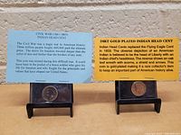 Two coins displayed side by side with informative placards. Left placard describes the Civil War Indian Head Cent (1861-1865) and its historical context. Right placard describes the 1889 Indian Head Cent plated with 24kt gold and its features.