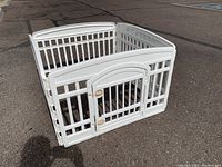 Photo of pet pen showing front corner where two panels meet and the door panel with two latches visible.