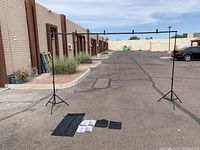 Full view of the assembled backdrop stand system outdoors, showing the height and width with the stands and crossbar connected.