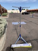 Full view of the assembled tripod drying rack with blue and metal finish and multiple arms for hanging.