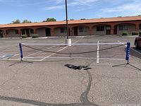 Full view of the portable net set up in an empty parking lot showing its length and height.