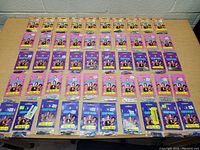 Front view of 50 packages of new Roley Poley Hair Decorations arranged in rows on a table.