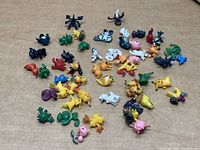 Overview of all small Pokemon figures spread on a surface showing size, condition, and variety